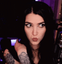 a woman with a tattoo on her wrist is making a funny face
