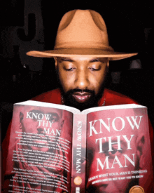 a man wearing a hat is reading a book called know thy man