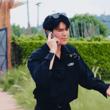 a man wearing a black shirt with a cbr logo on it talking on a cell phone