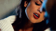 a close up of a woman 's face with her eyes closed and red lips