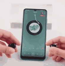 a person is holding a pair of earbuds next to a smart phone .