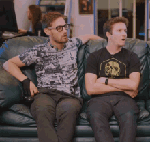 two men sitting on a couch with one wearing a shirt that says ' nirvana '