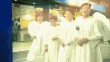 a group of angels in white robes are standing in a line