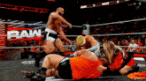 a group of wrestlers are wrestling in a ring while a crowd watches .