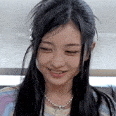 a girl with long black hair and a necklace with a cross on it