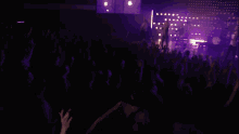 a woman is singing into a microphone in a dark room