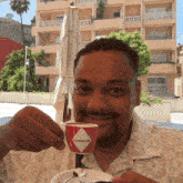 a man is drinking from a red cup that says " caffe milano " on it