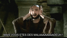 a man with a beard covering his ears with his hands and the words mais vous etes des malaaaaadeuh written below him