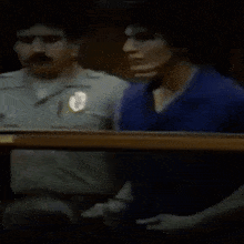 a man in a blue shirt is standing next to a man in a white shirt .