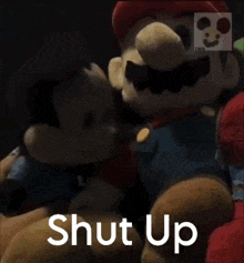 a close up of a stuffed mario and mickey mouse with the words shut up behind them