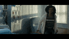 a woman is running in a hospital room with a bed