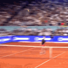 a blurred image of a tennis court with a blue sign that says ' santander ' on it