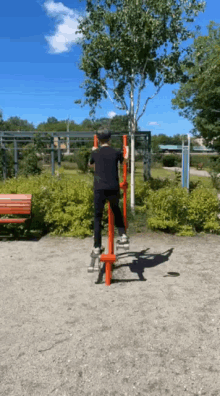 a man in a black shirt is doing exercises on a red machine