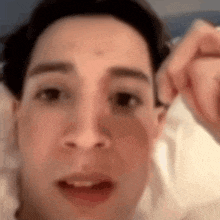 a close up of a person 's face with a hand behind their ear