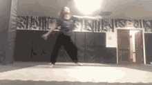 a young girl is dancing on a mat in a room .