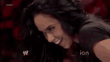 a woman is smiling in front of a sign that says ' ion ' on it