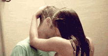 a woman washing a man 's hair in a shower