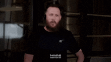 a man with a beard is wearing headphones and a black shirt that says what a day