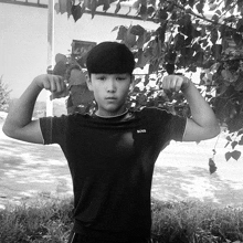 a boy flexing his muscles wearing a black shirt with the word boss on it