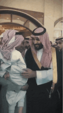 a man in a traditional costume is holding a child