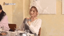 a woman wearing a head scarf is sitting at a table in a restaurant with other women .