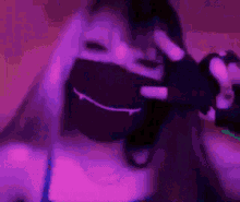 a girl is wearing a mask with a vampire face on it and making a peace sign .