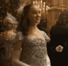 a woman in a blue dress and white gloves is standing in a room with other people .