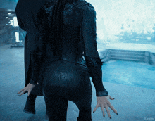 a woman in a black bodysuit is standing next to a man and the word kepler is on the bottom of the photo