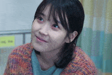 a close up of a woman 's face in front of a yellow sign that says ' ee ' on it