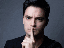 a man is holding his finger to his lips