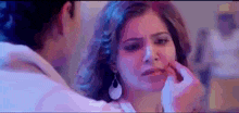 a man is applying makeup to a woman 's face .