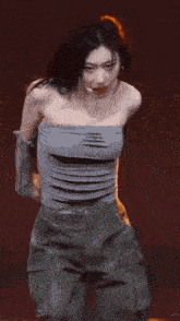 a woman is standing on a stage wearing a strapless top and shorts .