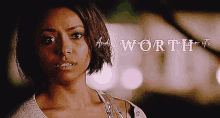 a woman with short hair is standing in front of a sign that says and i am worth it