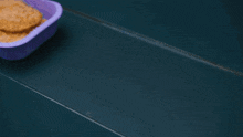 a purple plastic container with a piece of food inside of it
