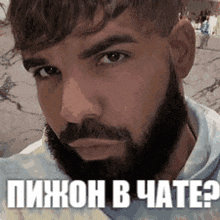 a man with a beard is taking a selfie with a foreign language .