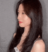 a woman with long black hair is wearing a black tank top and red lipstick