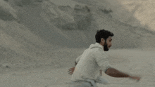 a man in a white shirt is running in the desert .