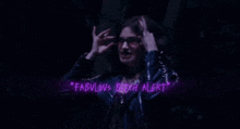 a woman in a leather jacket is giving the middle finger in a dark room .