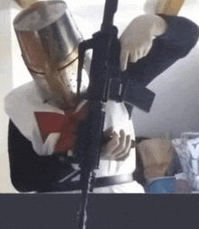a man in a knight 's costume is holding a gun .