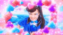a girl in a blue dress is surrounded by pink hearts and smiling .