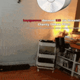 a room with a cd hanging from the ceiling and a sign that says kaygooween donated 25 via stream