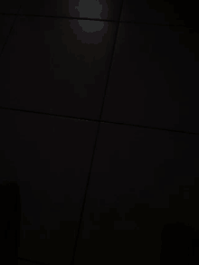 a person 's feet are on a white tile wall