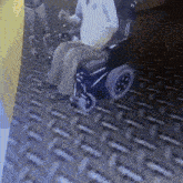 a man in a wheelchair is sitting on a metal surface
