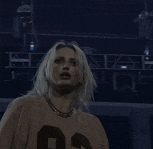 a woman wearing a jersey with the number 95 on it is holding her hair .