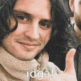 a close up of a man giving a thumbs up with the words idgaf written below him .