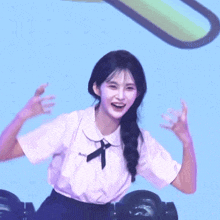 a girl wearing a white shirt with a black ribbon on the collar is smiling