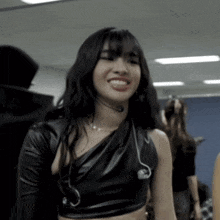 a woman wearing a headset and a black leather top smiles
