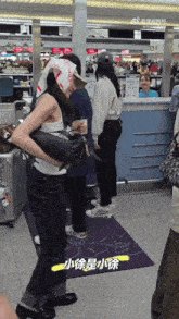 a woman with a scarf around her head is standing in a crowded airport