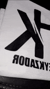 a white t-shirt with a black cross and the word rodasxy on it