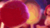 a close up of a pink lollipop with a purple background